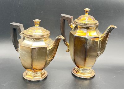 two silver and gold teapots sitting on a table
