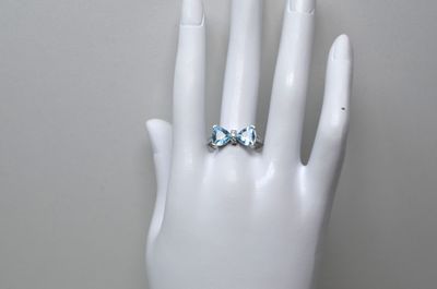 une main ornée d'une bague, posée sur un mannequin