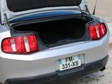 a silver car with its trunk open on the street