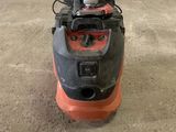 a close up of a red and black floor scruber on the ground