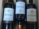 trois bouteilles de vin dans un coffret sur une table