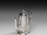 une théière ancienne en argent surmontée d'un oiseau