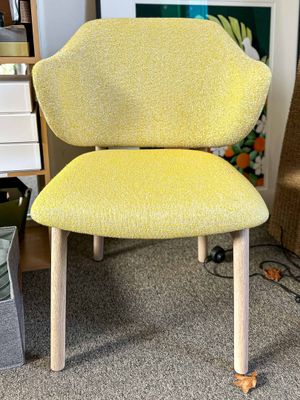 a yellow chair that is sitting in the corner of a room