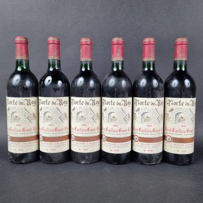 six bottles of red wine lined up in a row