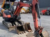 a small excavator that is sitting in a parking lot