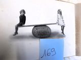 une photo en noir et blanc de deux enfants sur une balançoire à bascule