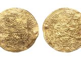 a close up of two gold coins with arabic writing on them