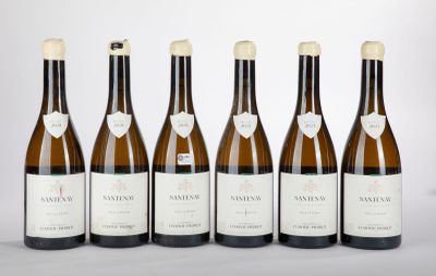 six bouteilles de vin sont alignées sur une table