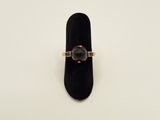 a close up of a ring with a black stone on it