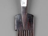 a wooden comb with a number on it on a gray surface
