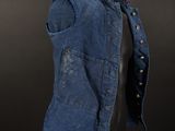 a blue denim vest on a mannequin stand against a black background