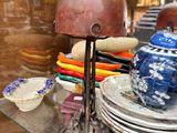 une étagère en verre sur laquelle sont posées des assiettes, des bols et une lampe