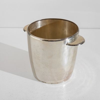 une coupe en argent munie d'une anse, posée sur une table
