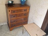 a small table with a lamp on it next to a chest of drawers