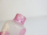 a pink glass vase with a pink flower design on it