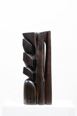 sculptures made of wood sit on a white pedestal against a white background