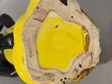 a figurine of a cat with a yellow hat on it