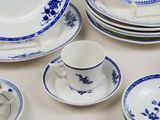 a lot of blue and white plates and cups on the table