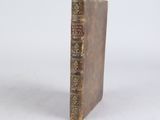 an old book sitting on top of a white surface
