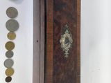 a small wooden box with coins on it next to other items