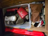 a red suitcase and a brown bag in the back of a van