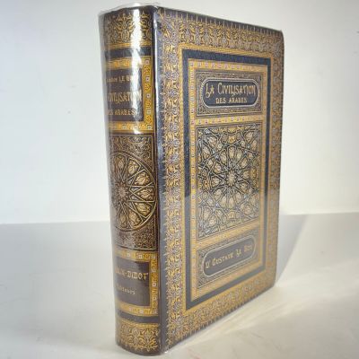 an old book sitting on top of a white table next to a white wall