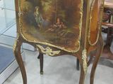 un petit meuble orné d'un tableau, dans une pièce