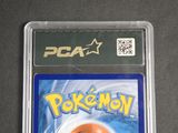 a pokemon card in a plastic case on a table