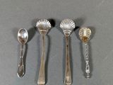 four spoons and a spoon rest on a table