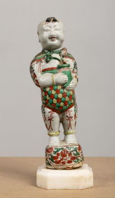 chinese porcelain figurine of a boy holding a bowl of fruit