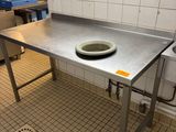une grande table en métal sur laquelle est posé un saladier, dans une cuisine