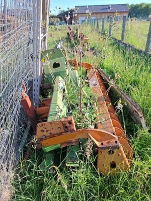un tracteur qui se trouve dans l'herbe derrière une clôture