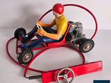 a figurine of a man driving a toy car