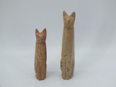 deux figurines de chats assis l'un à côté de l'autre