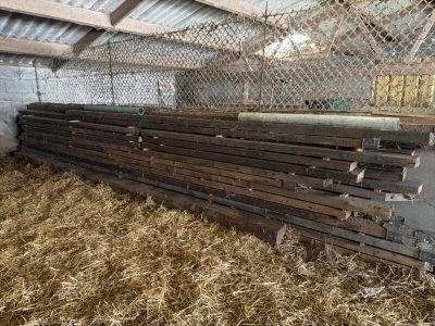 plusieurs morceaux de bois sont empilés les uns sur les autres dans une grange