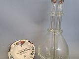 un petit vase en verre et une petite assiette posés sur une table