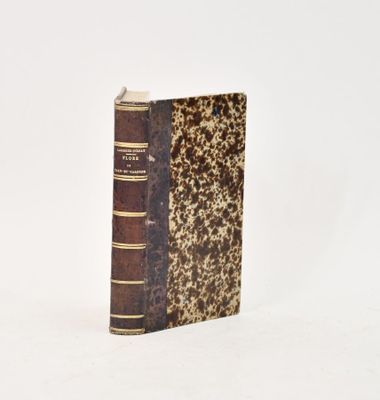 an old book sitting on top of a table next to a white wall