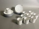 un grand nombre de tasses et de soucoupes sur une table