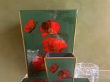 une table en verre sur laquelle se trouve un vase contenant des fleurs rouges