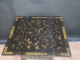 a black and gold table with a flower design on it