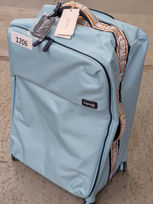 une valise bleue avec une étiquette, posée sur le trottoir