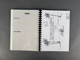 an open notebook with a drawing of a beach scene and palm trees