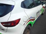 a white car with a green stripe parked on the side of the road