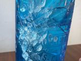 a blue glass bottle with water in it sitting on a table