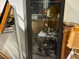 une vitrine sur laquelle est accrochée une peinture, dans une pièce
