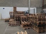 a large warehouse with pallets of wood in the middle of the floor