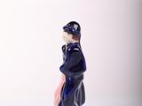 a figurine of a man standing on a white surface