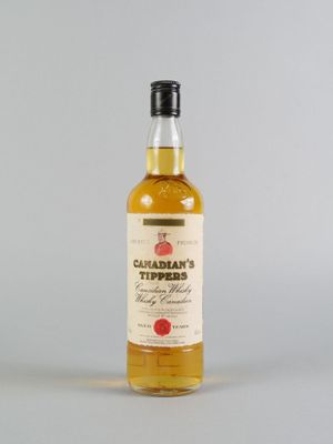 une bouteille de sirop d'érable canadien posée sur une surface blanche