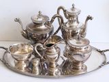 a silver tray with a silver tea set on it