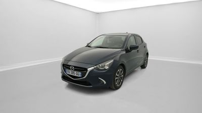 Une voiture grise est garée dans une pièce blanche au sol blanc.